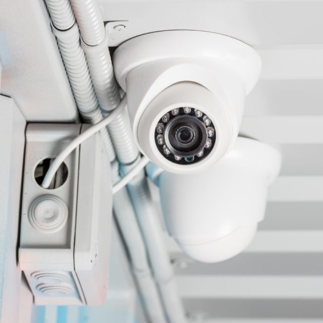 white security camera on ceiling, home security system concept
